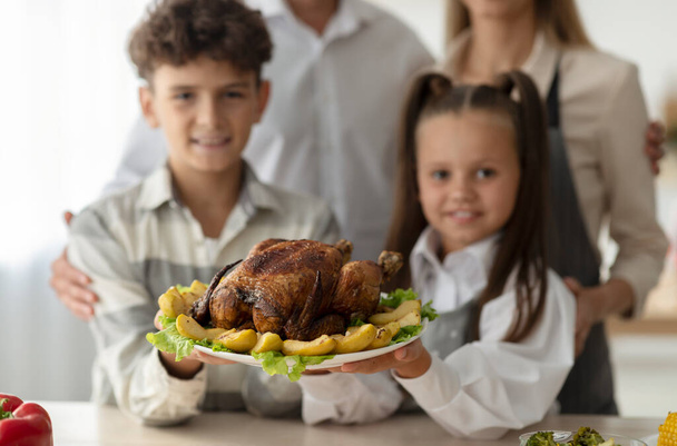 Bambini e genitori felici con tacchino arrosto servito con mele sul piatto per la cena di Natale, focus selettivo - Foto, immagini