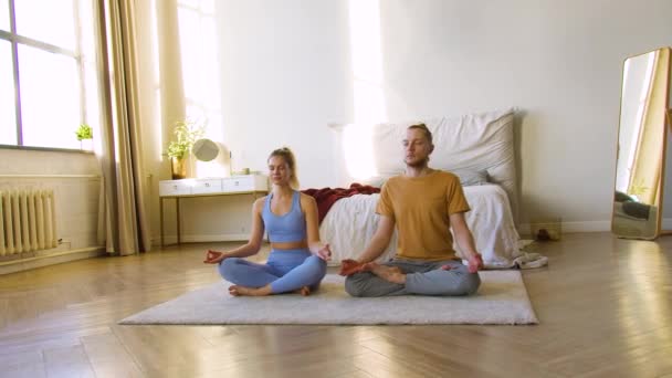 4k映像の若いカップル瞑想で自宅一緒に. - 映像、動画