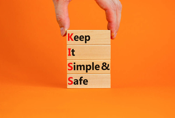 KISS keep it simple and safe symbol. Concept words KISS keep it simple and safe wooden blocks. Beautiful orange table, orange background. Business and KISS keep it simple and safe concept. Copy space. - 写真・画像