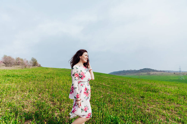 beautiful woman in a spring dress in a blooming garden with green grass - Foto, Imagem