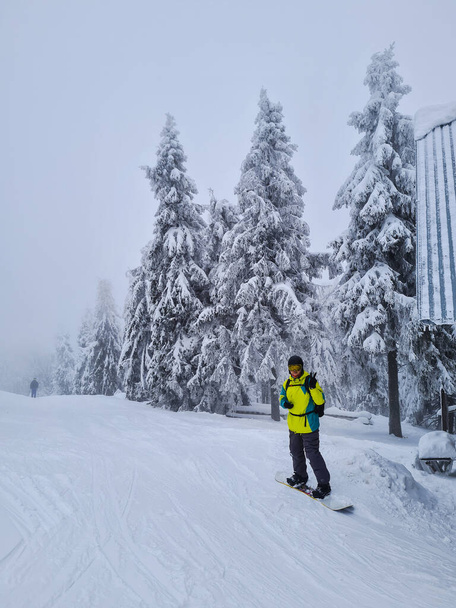 man snowboarder op poeder besneeuwde helling winter extreme sport - Foto, afbeelding