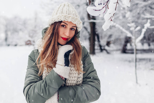 Muotokuva kaunis nuori nainen luminen talvipuisto yllään lämmin neulotut vaatteet ja punainen juhlava huulipuna nauttia sää lumen alla ulkona. - Valokuva, kuva