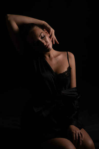 piękna kobieta w czarnej jedwabnej bieliźnie w ciemności - Zdjęcie, obraz