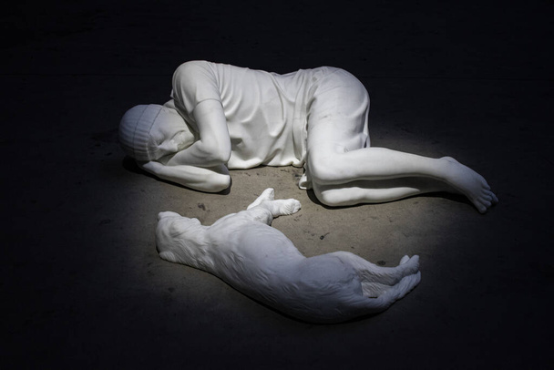 Milán, Italia, 5-12-2021: vista de Breath Ghosts Blind de Maurizio Cattelan, una escultura de mármol blanco de Carrara que representa a una persona y un perro tumbados uno frente al otro en Pirelli Hangar Bicocca - Foto, imagen
