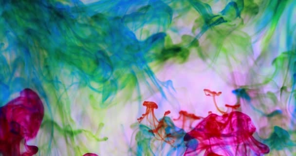 Video hipnótico y relajante de tintas de colores flotando en agua transparente creando rizos y olas de agua - Imágenes, Vídeo