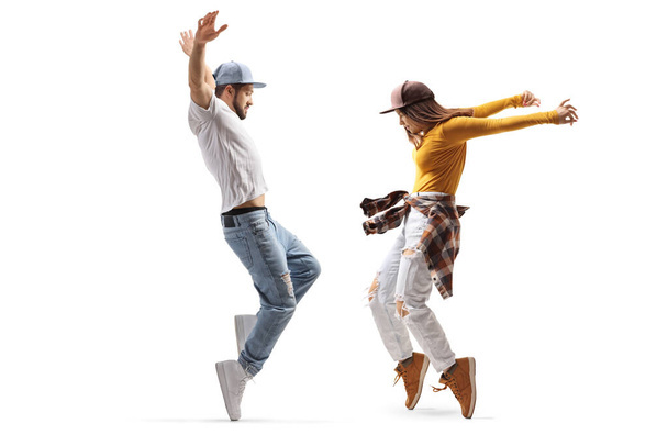 Full length profile shot of a female and male dancer in casual clothes dancing on tiptoes isolated on white background - Photo, Image
