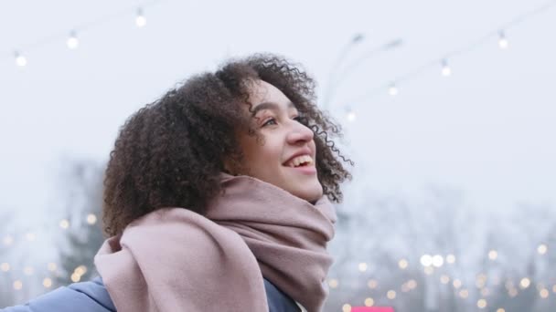 Портрет красивой молодой беззаботной смешной брюнетки афро-американской девушки туристической подруги 20 лет леди в теплой одежде стоит зимой в городе глядя в небо мечтая улыбаясь смеясь - Кадры, видео