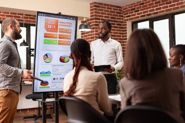 Diverse entrepreneurs analyzing financial statistics working at business presentation - Photo, Image