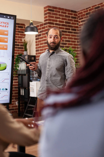 przedsiębiorca człowiek wskazując na monitor wyjaśniający statystyki zarządzania - Zdjęcie, obraz
