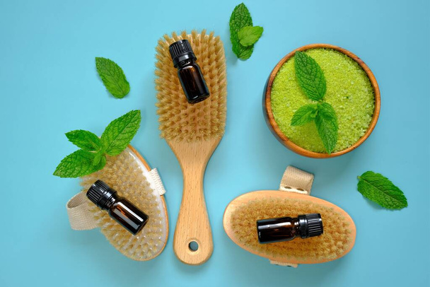 Peppermint salt .natural bristle body brushes, green salt in a round wooden bowl and sprigs of peppermint . Natural cosmetics and aromatherapy.Organic natural cosmetics for body with mint extract - Photo, Image