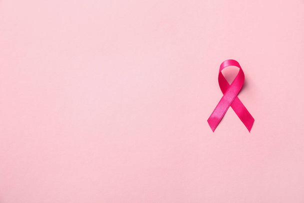 Pink ribbon on color background, top view with space for text. Breast cancer awareness concept - Foto, Imagem