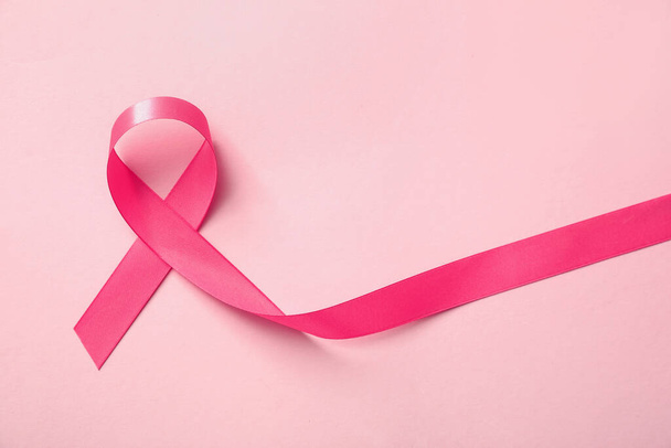 Pink ribbon on color background, top view. Breast cancer awareness concept - 写真・画像