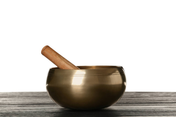 Golden singing bowl and mallet on wooden table against white background - Fotografie, Obrázek