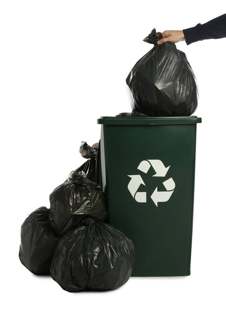 Man putting garbage bag into recycling bin on white background, closeup - Valokuva, kuva