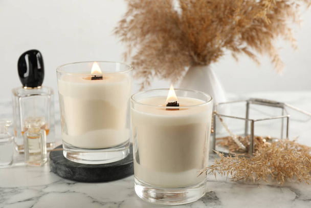 Composition with burning soy candles on white marble table - Foto, Bild