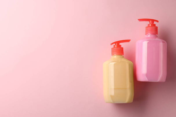 Bottles of liquid soap on pink background, flat lay. Space for text - Photo, Image