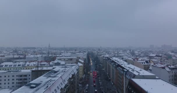 Tył ujawniam śnieżny zakurzony miasto o zmierzch. Mały ruch na ulicach. Widok z lotu ptaka na duże miasto. Berlin, Niemcy - Materiał filmowy, wideo
