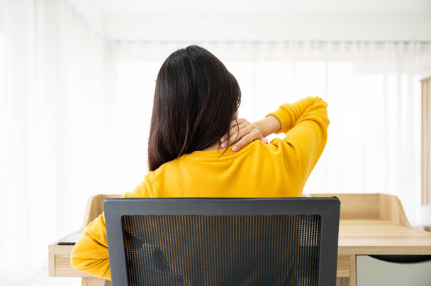 オフィス症候群の概念。若いアジアの女性は長い時間のためのコンピュータのラップトップで作業した後、首に痛みを感じる - 写真・画像
