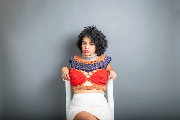 beautiful perfect skinned afro hispanic model sitting winking - Foto, Imagen