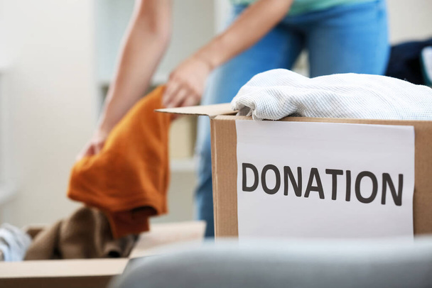 Cardboard box with clothes for donation in room, closeup - Φωτογραφία, εικόνα