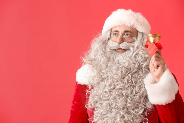 Santa Claus con campana de Navidad sobre fondo rojo - Foto, Imagen