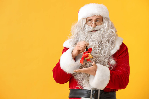 Santa Claus with Christmas bell on yellow background - Zdjęcie, obraz