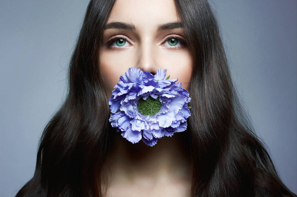 Bella donna con fiore in bocca. Bellezza Ritratto di ragazza sensuale con Fiore Blu - Foto, immagini