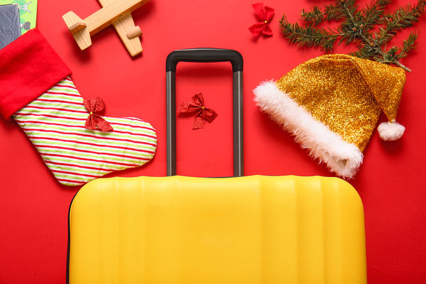 Samenstelling met koffer, Santa hoed, sok en houten vliegtuig op kleur achtergrond, close-up. Kerstvakantie concept - Foto, afbeelding