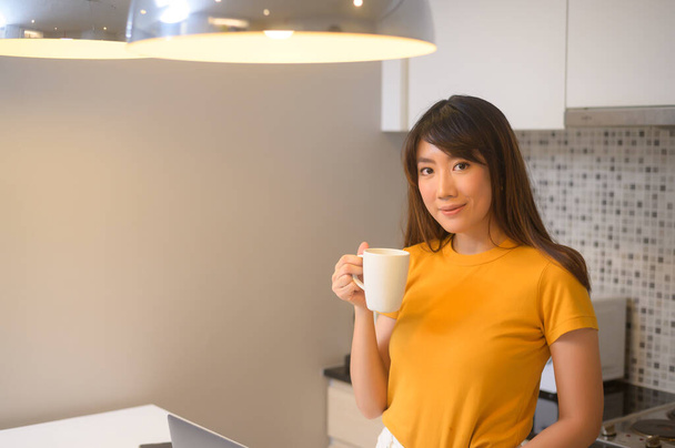 A young female working with her laptop and having a cup of coffee, life style and business concept - Photo, Image