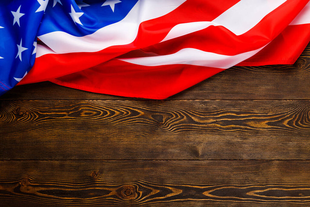 crumpled usa flag on flat textured wooden surface background - Фото, изображение
