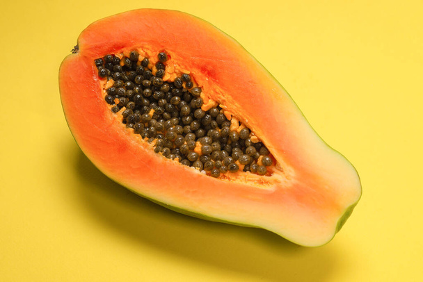 Fruto de papaya sobre un fondo amarillo. Fruta tropical. Mitad papaya.  - Foto, Imagen