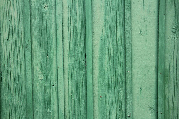 Old weathered painted bright green wooden wall of the fence with vertical planks background texture - Фото, изображение