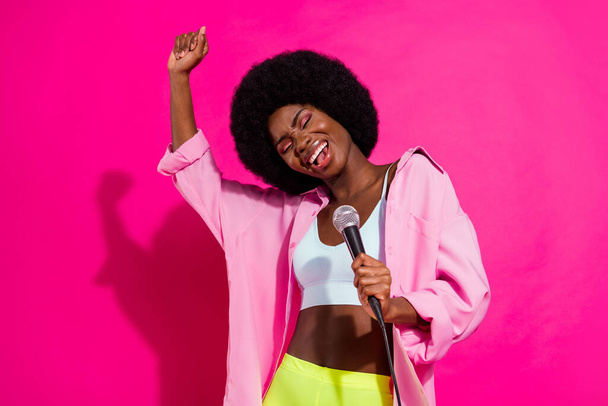 Photo of adorable sweet dark skin woman dressed crop top smiling dancing singing songs isolated pink color background - Foto, Bild