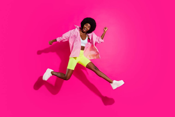 Full length body size view of lovely slender cheerful girl jumping running having fun isolated over bright magenta fuchsia color background - Foto, imagen
