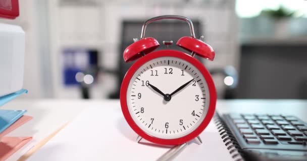 Reloj despertador rojo para diez relojes con documentos en la oficina - Imágenes, Vídeo