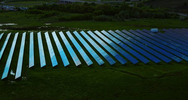 Drone view zonnepanelen park in groen veld. Rijen zonne-energie vanuit de lucht  - Foto, afbeelding