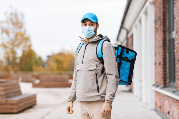 delivery man in mask with thermal bag in city - Fotó, kép