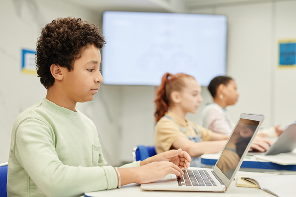 Számítógépet használó fiú az osztályban - Fotó, kép