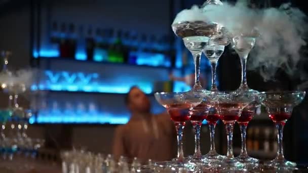 Pyramids from glasses on the bar. Liquid is poured into them and steam comes out. Selective focus - Footage, Video