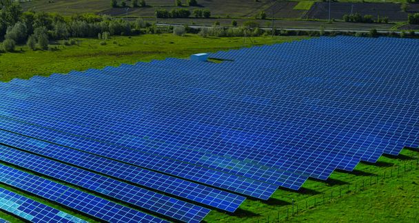 Letecký pohled na modré solární panely na přírodním pozadí. Koncept obnovitelné energie. - Fotografie, Obrázek