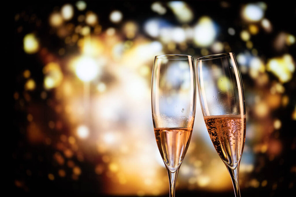 two champagne glasses and festive light happy New Year - Фото, изображение