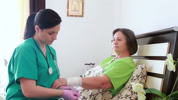yaralı kadın kıdemli kolunu bandaj hemşire - Video, Çekim