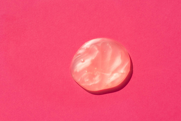 Персиковий гель Shimmer. Косметичні мазки та краплі. Поява текстури рідини на рожевому фоні. Натуральні продукти для догляду за шкірою. Концепція краси для догляду за обличчям і тілом
 - Фото, зображення