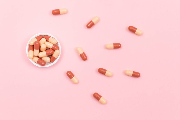 Pharmaceutical Industry and Medicinal Products - Colored Pills on Pink Table - 写真・画像