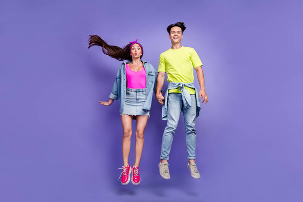 Photo of romantic vintage couple jump hold hands girl send air kiss wear pin-up outfit isolated violet color background - Photo, image