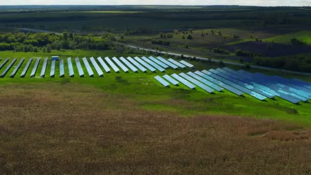 Widok z lotu ptaka niebieski panel słoneczny park. Farma baterii słonecznych w zielonym polu.  - Materiał filmowy, wideo