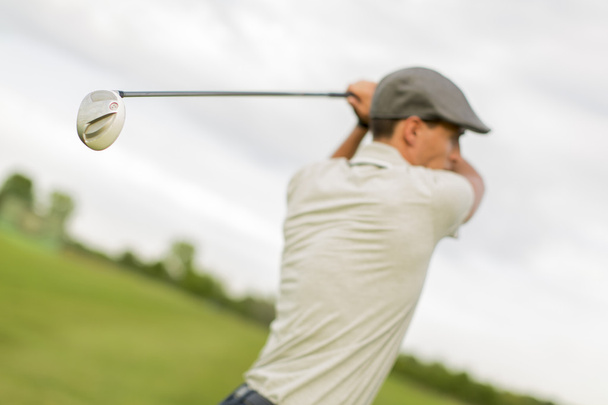 Young man playing golf - Fotó, kép