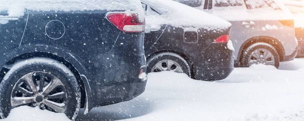Városi utcai felhajtó parkoló sok autó által borított hó ragadt után nagy hóvihar hóesés téli napon piszkos havas halom. Hó sodródások és fagyott járművek. Extrém időjárási körülmények - Fotó, kép