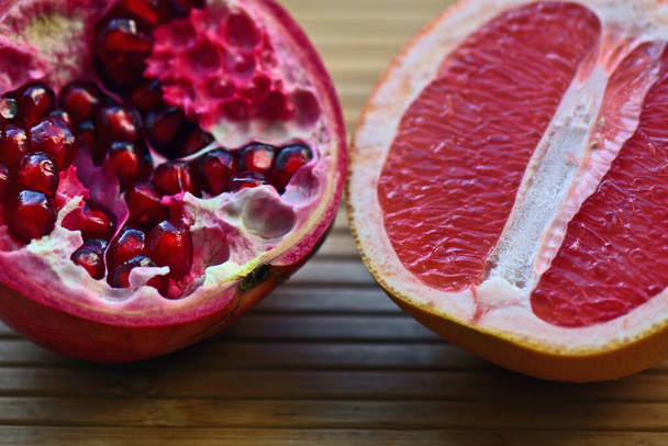 pomegranate and grapefruit on a wooden table - Photo, Image