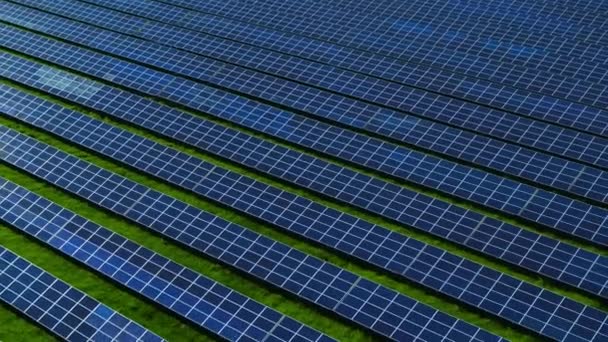 Photovoltaikanlagen aus der Luft parken auf der grünen Wiese. Blauer Himmel spiegelt sich - Filmmaterial, Video
